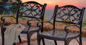 Buyer's Guide Cast Aluminum Outdoor Dining Chairs featured - two aluminum chairs on a patio and sunset